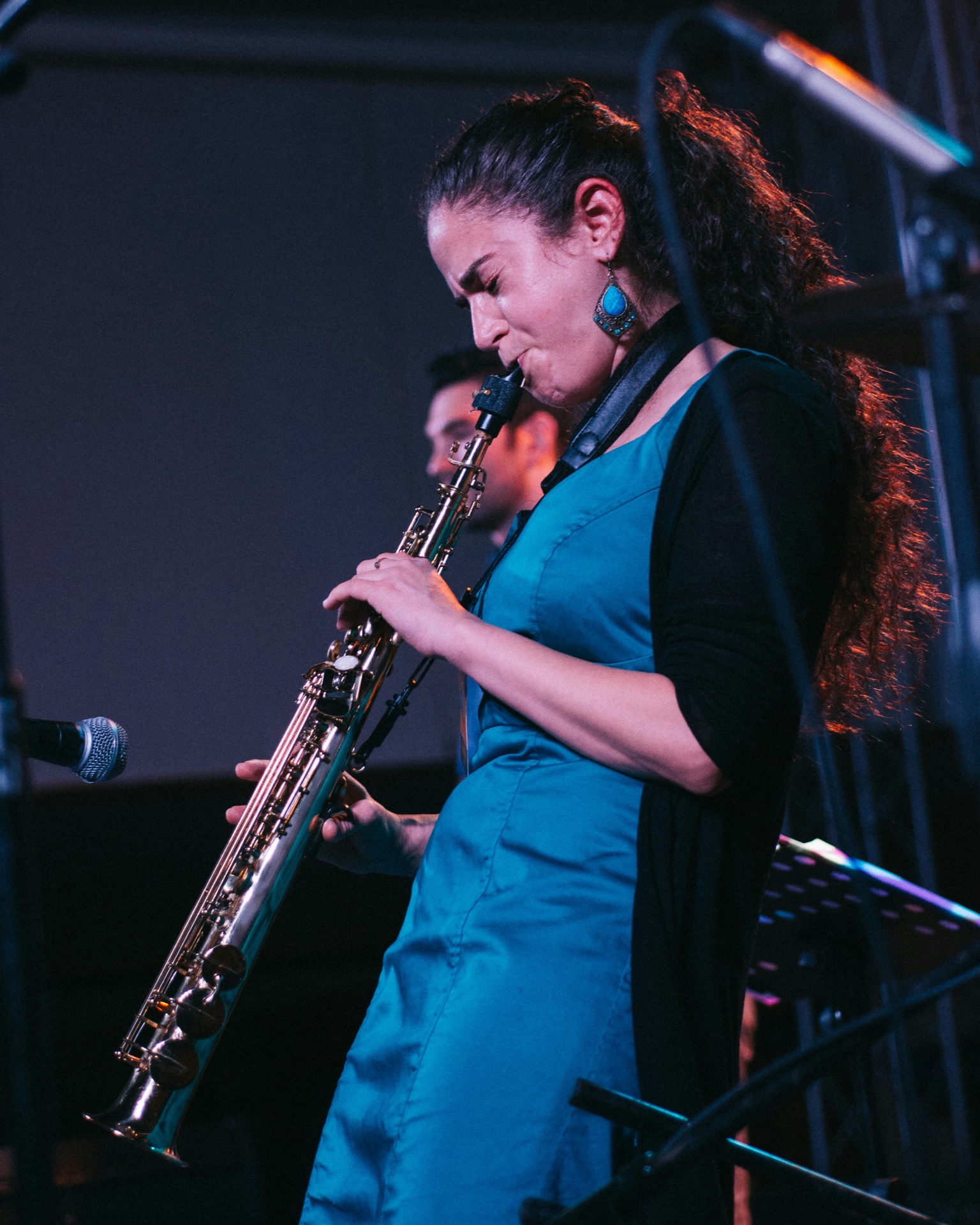 Muzikant met saxofoon in warm podiumlicht. Muziekpolis verzekert muziekinstrumenten.